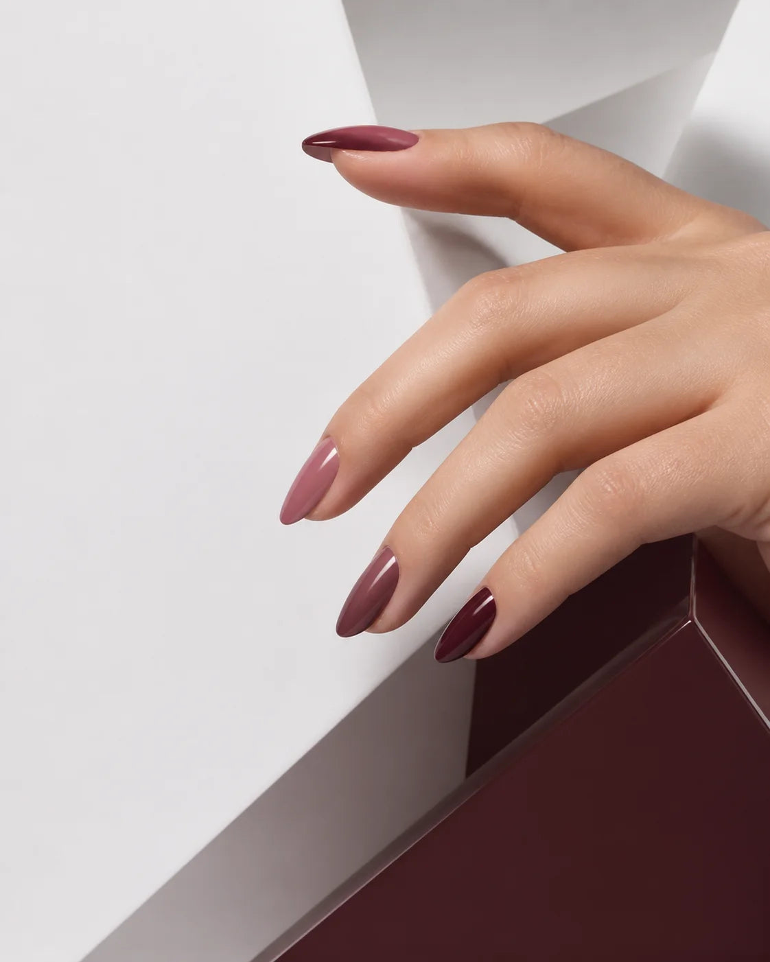 Wine and rose almond nails styled in bright architectural light